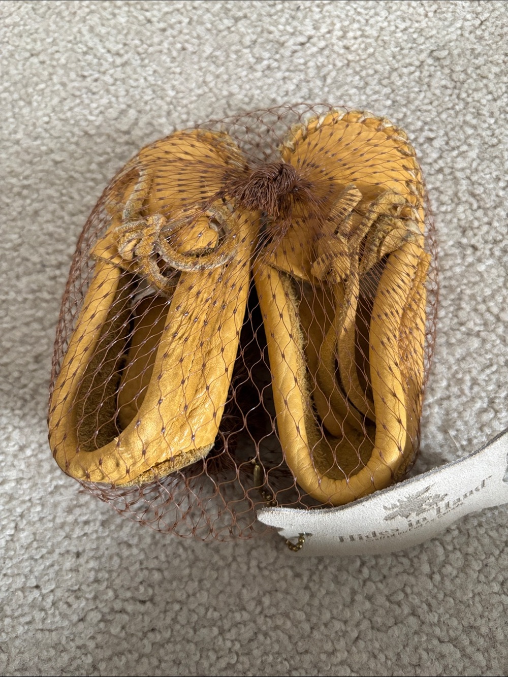 Hides in Hand. Tan baby Moccasins